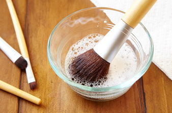 How should you clean your makeup brushes?